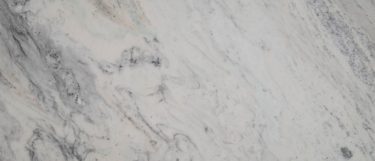 an Arabescus White marble countertop surface that features swirl and vein details in gray, dove, and charcoal over the white background