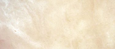 a Crema Marfil El Marble countertop surface that has a cream color with soft veins in yellow, cinnamon, white, and tan