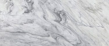 a Brazil Calacatt marble countertop surface that features rich veining and swirling pattern in gray over the white background