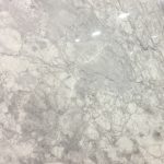 a super white marble countertop surface that has a dramatic white and gray veining pattern