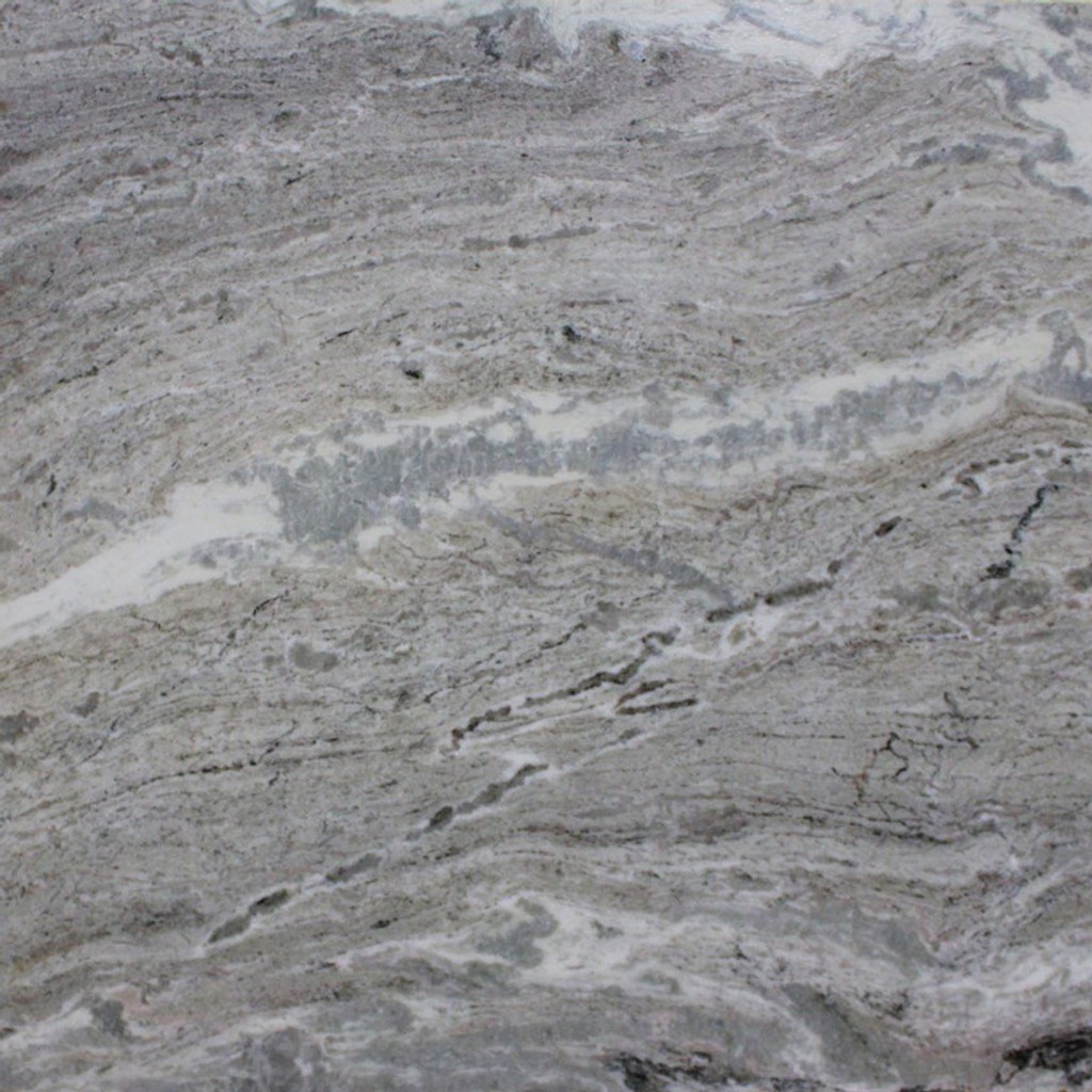 a Fantasy Brown marble countertop surface that has brown and sandy hues with a flowing pattern of white, brown, and gray veins with black spots throughout