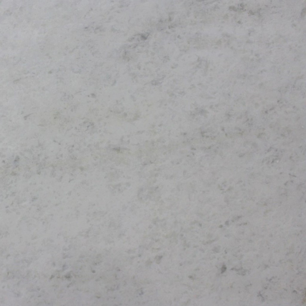 an Everest White marble countertop surface that features delicate veins and plumes of gray over the white background