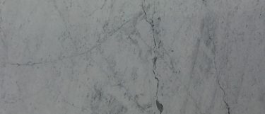 a Bianco Carrara marble countertop surface that features streaks of black and gray over the cloudy white background
