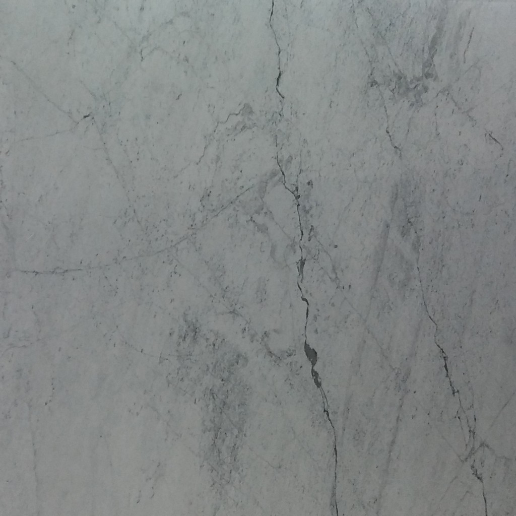 a Bianco Carrara marble countertop surface that features streaks of black and gray over the cloudy white background