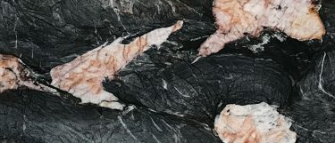 a Crytos countertop surface that features pops of color in gray, white, and amber throughout the black backdrop