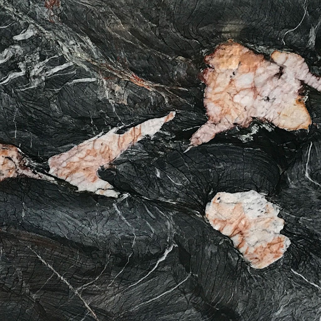 a Crytos countertop surface that features pops of color in gray, white, and amber throughout the black backdrop