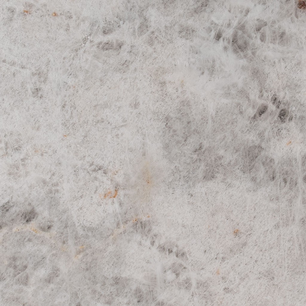 a Cristallo quartzite countertop surface that features gray and orange flecking and veining details over the cool white background
