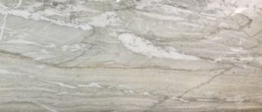 a Nauge quartzite countertop surface that has brown, gold, and white line streaks over the gray background