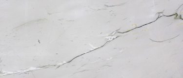 a Mont Blanc quartzite countertop surface that features dramatic charcoal veining pattern with white crystals and gold details over the cool white background