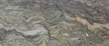 a Blue Fusion quartzite countertop surface that features shades of bluish gray, creams, and rust colors that are blended together in a swirling wavy pattern