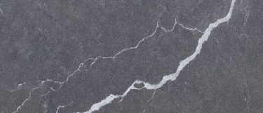a Cemento quartz countertop surface that features threads of white veins over the gray background