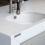 a modern sink over the white storm countertop surface