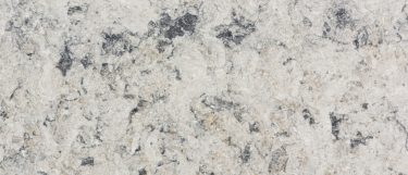 an urban frost quartz countertop surface that has a soft white background with gray and taupe speckling effect
