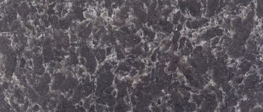 an ocean storm quartz countertop surface that features a dark blue-gray background with a veining pattern in white