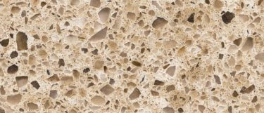 a Bamboo quartz countertop surface that features pebble patterns in brown, chocolate, white, gray, and taupe over the beige base