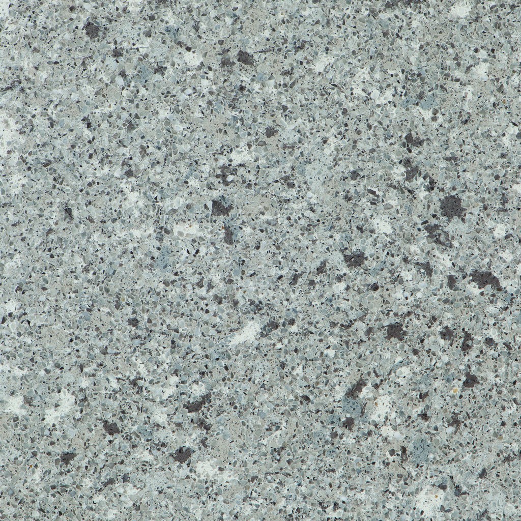 an Alpina White quartz countertop surface that features a pebbled-like pattern in gray, white, and brown over the creamy gray background