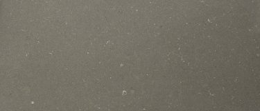 a Fossil Brown quartz countertop surface that features subtle shading and vein details over the mid-tone brown background