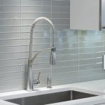 a sink over the morning frost countertop and against the gray tile backsplash