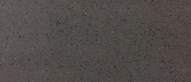 a Concrete Gray quartz countertop surface that features gray color with dark grays and black specks