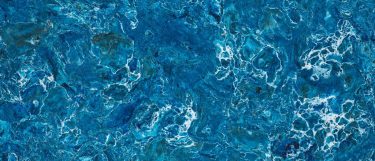 a Skye quartz countertop surface that has a vibrant blue design with various shades of blue and white vein ripple pattern