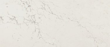 a Colton quartz countertop surface that features brownish gray veining and small white patches over the creamy white background
