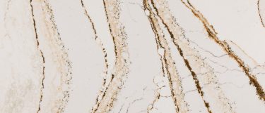 a Clovelly quartz countertop surface that features veining details in copper and brown over the creamy background