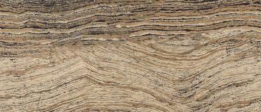 a Clairidge quartz countertop surface that features waving pattern of striations of tan, walnut-brown, cream, back, and gray with dark vein details
