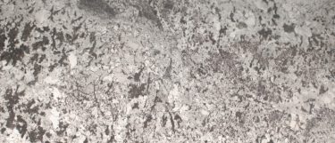 a white splendor granite countertop surface that features a white base covered in rich, dark, gray veining