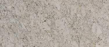 a snowfall granite countertop surface that has a warm design with light and dark specks over the white background