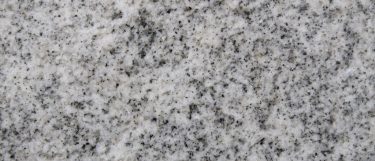 a smoky white granite countertop surface that has a clean gray design with flecks of gray over the smoky white background
