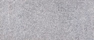 a new caledonia granite countertop surface that has a range of colors in grays and white