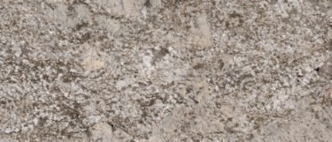 a white sands granite countertop surface that features a creamy white background with gold, beige, and brown flecks