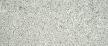 a white alpha granite countertop surface with dark gray flecks that contrasts on its soft white background