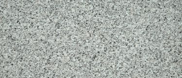 a valle nevado granite countertop surface that features a light cream base with speckled pattern of white, black, gray, and taupe