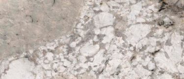 a sunset canyon granite countertop surface that features white and taupe accents with black veins over the beige background