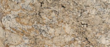 a summer beach granite countertop surface that features beige, gold, and black veins over the soft cream background