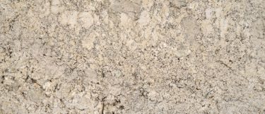 a snowfall granite countertop surface that has a warm design with light and dark specks over the creamy beige background