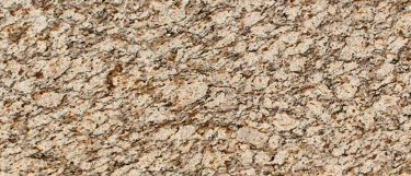 a santa cecilia granite countertop surface that blends warm colors of yellow, gold, black, and burgundy