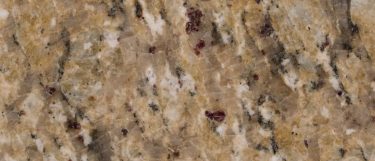 a New Venetian Gold granite countertop that features veining pattern of red, grays, and brown over its golden beige surface