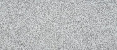 a Jasmine White granite countertop surface that has a grainy specks of gray over the white background
