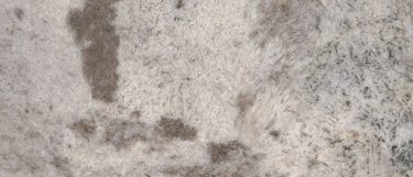 a Gray Nuevo granite countertop surface that has dark gray and brown specks and veins over the white background