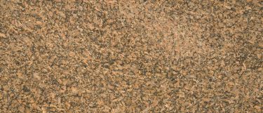 a Giallo Vicenza granite countertop surface that has black and gold details combined with spots of warm brown and tan