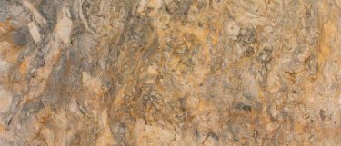 a Fusion granite countertop surface that features a combination of grays, creams, and rust colors in a swirling pattern
