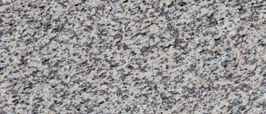 a Crema Perla granite countertop surface that combines colors of gray, cream, white, and black