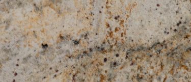 a Colonial Cream granite countertop surface that features flecks of gold, brown, gray, and rust over the creamy base