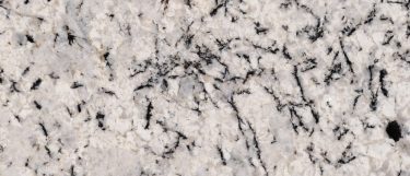 a Blizzard granite countertop surface that features dramatic gray veins over the soft white background