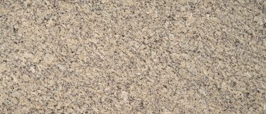 a Blanco Tulum granite countertop surface that features taupe and obsidian speckles with beige and eggshell white tones