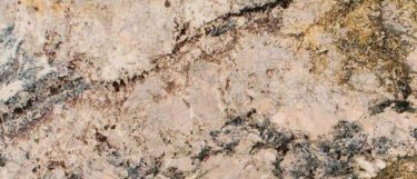 an Azurite granite countertop surface that features swirls of creams and brown with dark veining