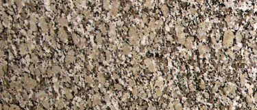 an Autumn Beige granite countertop surface that features specks of black and creams over the beige background