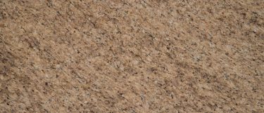 an Amarello Ornamental granite countertop surface that features a rich color of grays, beige, yellow, and cream